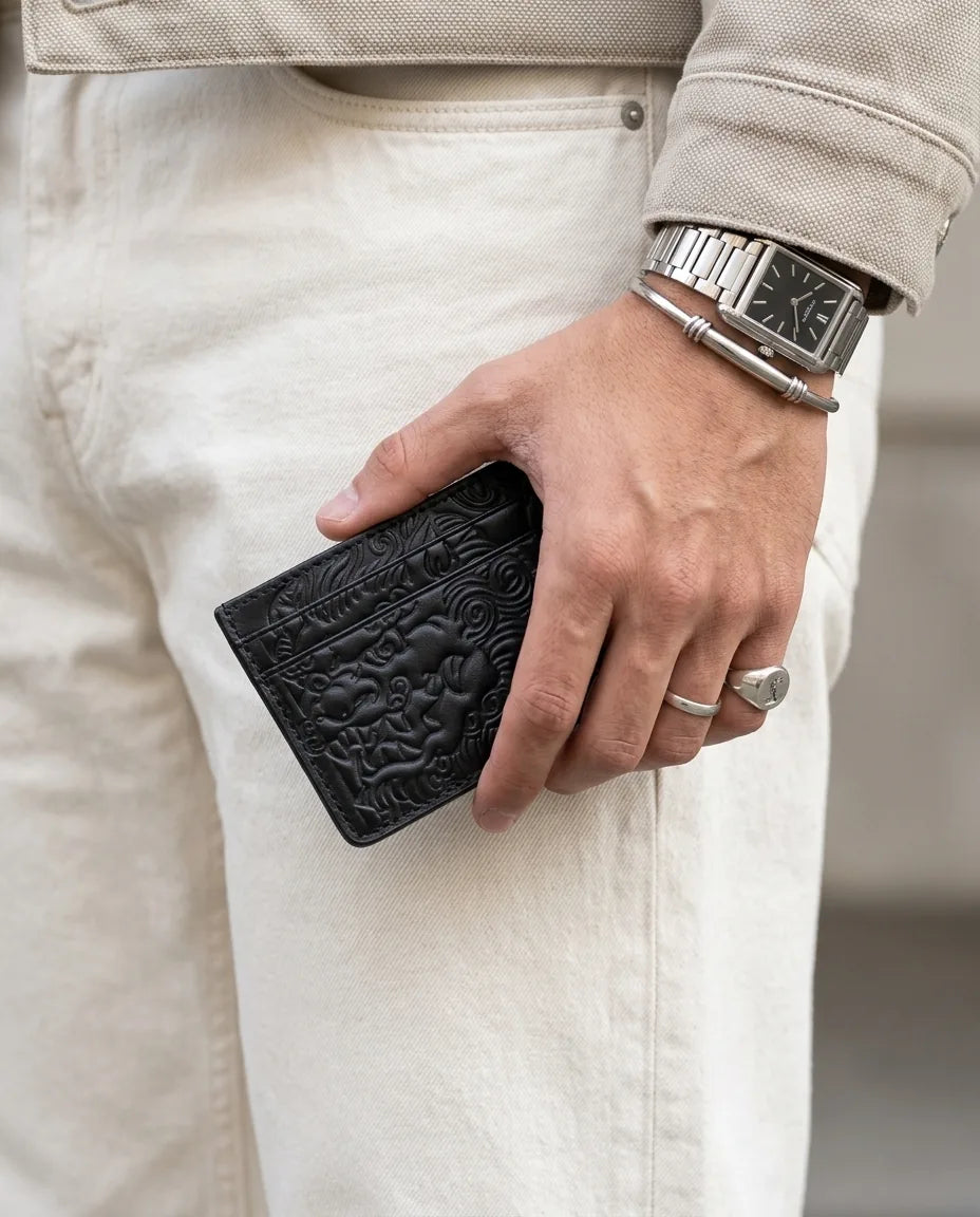 Ink Black shishi embossed card holder, held in hand