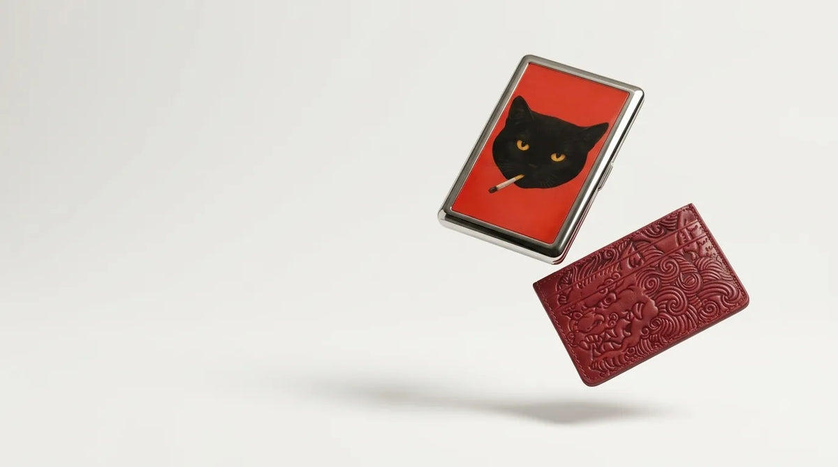 Alley Tom tin card case and oxblood embossed leather card holder floating on a light background